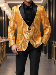 A man wears a gold paisley patterned blazer with a black notched lapel and single button closure.