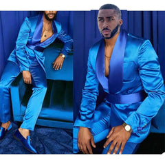 A man wears a vibrant blue two-piece suit featuring a shawl lapel jacket and matching trousers.