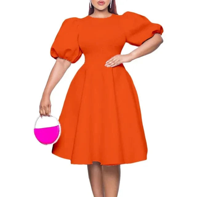 A woman wears a bright orange A-line dress with short lantern sleeves and a high waist.