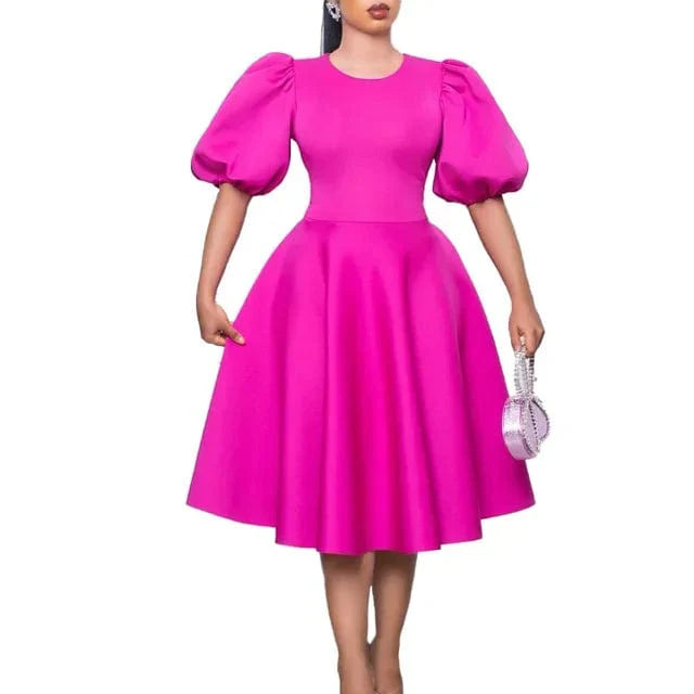 A woman wears a bright pink A-line dress with short lantern sleeves and a high waist.