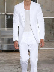 A man wearing a white two-piece suit with a single-breasted blazer and matching trousers.