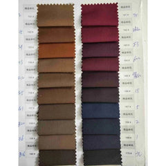 A fabric swatch book displays two columns of textile samples in various brown and red shades.