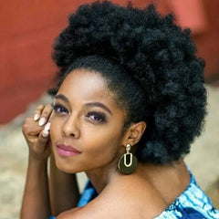 A woman wears a 10-inch kinky curly synthetic afro puff drawstring ponytail extension.
