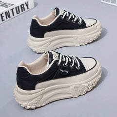 A pair of black and white platform sneakers with lace-up closures and a chunky textured sole.