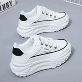 A pair of white platform sneakers with black heel tabs and lace-up closures.