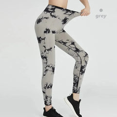 A person wears grey high-waisted seamless leggings featuring a black tie-dye pattern.