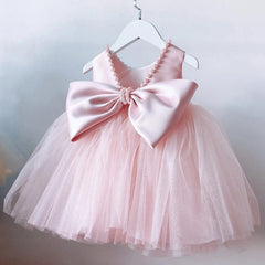 A sleeveless light pink toddler dress featuring a large satin bow and pearl trim on the back.