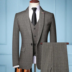 Un traje de hombre de tres piezas en color gris con blazer, chaleco y pantalón a juego.