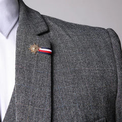 Close-up of a grey plaid blazer featuring a gold star lapel pin with a red, white, and blue ribbon.