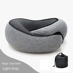 A light gray memory foam travel neck pillow with a black mesh lining and a matching storage bag.