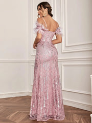A woman wears a floor-length, pink sequined formal dress with spaghetti straps and feather-trimmed cold-shoulder sleeves.