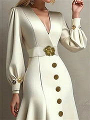 A cream-colored V-neck midi dress with puff sleeves, gold buttons, and a floral-accented belt.