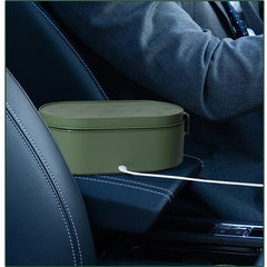 An olive green electric lunch box sits on a car center console connected by a USB cable.
