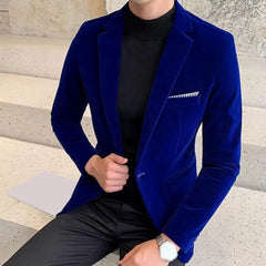 A man wears a slim-fit royal blue velvet blazer with a single button and a turndown collar.