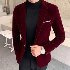 A man wears a slim-fit burgundy velvet blazer with a single button and a black turtleneck.