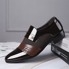 A glossy brown and black slip-on dress shoe with a pointed toe and mesh side panel detail.