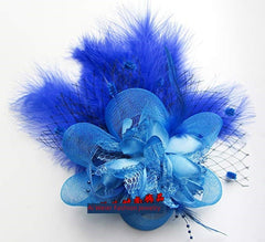 A vibrant blue fascinator hair clip featuring layered mesh petals, feathers, and netting.