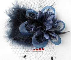A dark blue floral hair clip featuring layered fabric petals, feathers, and a decorative net veil.