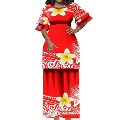 A woman wears a red two-piece Polynesian-style dress with white floral and tribal patterns.