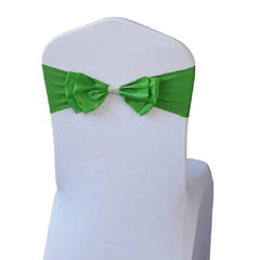 A bright green spandex chair sash with a pre-tied bow and a decorative rhinestone center band.