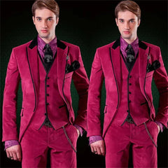 A man wears a three-piece magenta velvet suit with a patterned purple shirt and black tie.