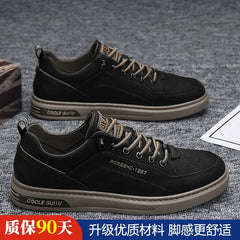A pair of black casual men's sneakers with tan soles and laces.