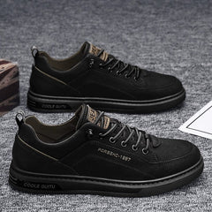 A pair of black casual men's sneakers with lace-up closures and rubber soles.