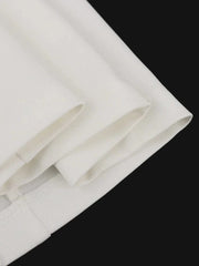 A close-up view of the white fabric folds and hemline of a blazer dress.
