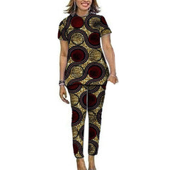 A woman wears a matching short-sleeved top and pants set featuring a circular African print pattern.