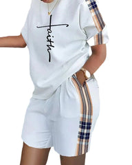 A white two-piece set featuring a faith-printed t-shirt and shorts with plaid side stripes.