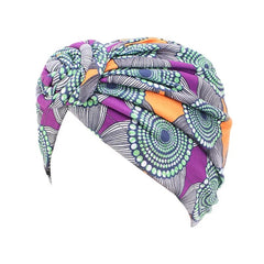 A purple and orange patterned cotton turban hat with a decorative front knot.