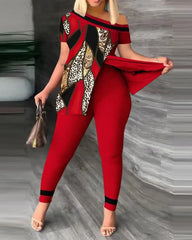 A woman wears a red two-piece set featuring a short-sleeved, off-shoulder top and skinny pants.