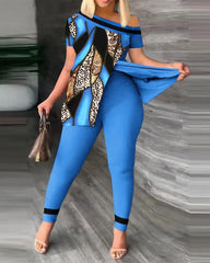 A woman wears a blue two-piece set featuring a short-sleeved, off-shoulder top with a patterned panel.