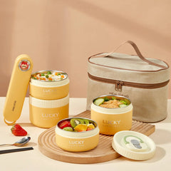 A yellow stackable stainless steel lunch box set with a matching insulated carrying bag.