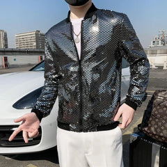 A man wears a silver sequined bomber jacket with a black ribbed collar, cuffs, and hem.
