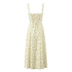 A cream-colored midi dress with a yellow floral print, square neckline, and lace-up back detail.