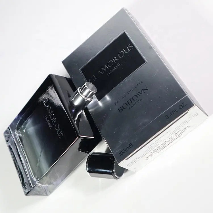 A bottle of 100ML OEM/ODM EDP men perfume, known for its long-lasting fragrance, sits next to its sleek silver and black packaging with the cap nearby on a white surface.