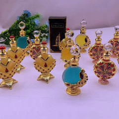 A collection of ornate, peacock-themed perfume bottles with gold accents and crystal stoppers.