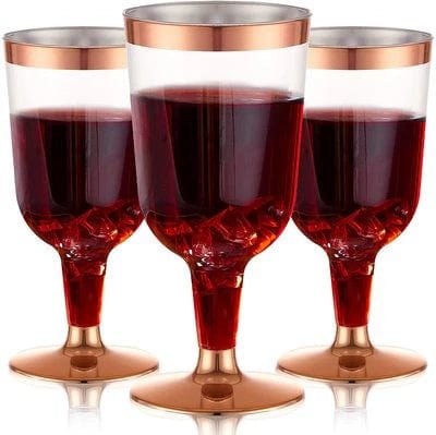 Rose gold disposable tableware set with plastic plates, cups, knives, forks, and spoons for parties and events.