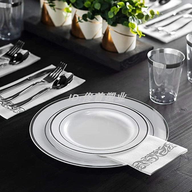 Rose gold disposable tableware set by Showlu with plastic plates, cups, wine glasses, knives, forks, and spoons.