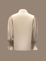 A solid beige long-sleeved shirt with a lapel collar and ruffled cuffs shown from the back.