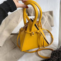 Chonghui women's triangle chain bucket bag made of PU leather, crossbody style with chain details and spacious interior.
