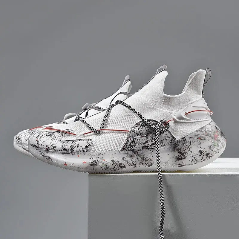 The 2022 Top Sale Fashion Sneaker features white mesh panels, black and gray abstract soles and sides, unique lacing, and red accents. These recycled men’s shoes are breathable, lightweight, with a modern look against a plain gray background.