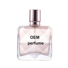 A square glass perfume bottle with a metallic cap and light pink liquid inside.