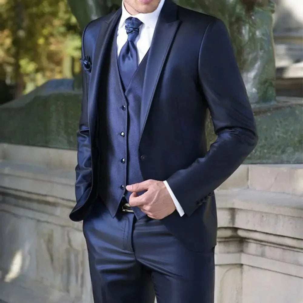 Navy blue Showlu Fashion groom tuxedo with peak lapel, slim fit jacket, pants, and vest for wedding or formal event.