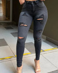 Showlu Women's grey ripped skinny jeans with mid waist, stretch denim, featuring distressed holes and a fitted, casual style.