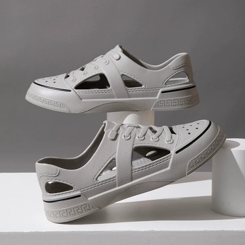 White WNCNATIVE breathable beach sandals with closed toe design, casual wading shoes for men and women, shown on a sandy beach.