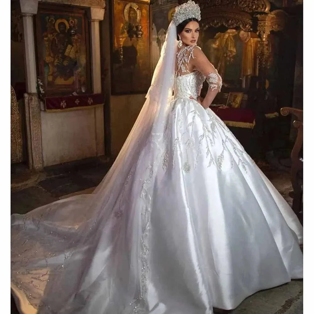Beaded satin O-neck ball gown wedding dress with chapel train and appliques, featuring long sleeves and intricate beadwork.