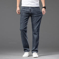 A man wears dark blue straight-leg denim jeans with a medium wash and a comfortable fit.