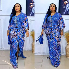 A woman wears a blue and purple patterned long-sleeved hooded maxi dress with a front slit.